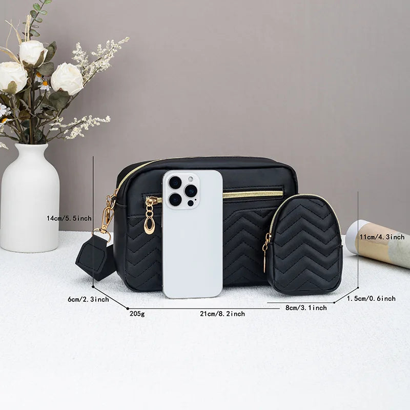 Black quilted crossbody bag next to a phone for size