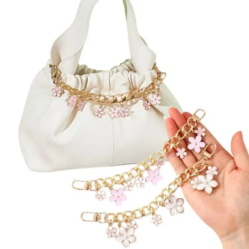Blossom bag charm chains clipped on a white handbag